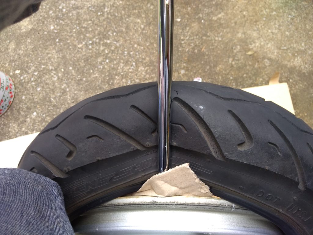 タイヤレバーを押し込んで持ち上げる