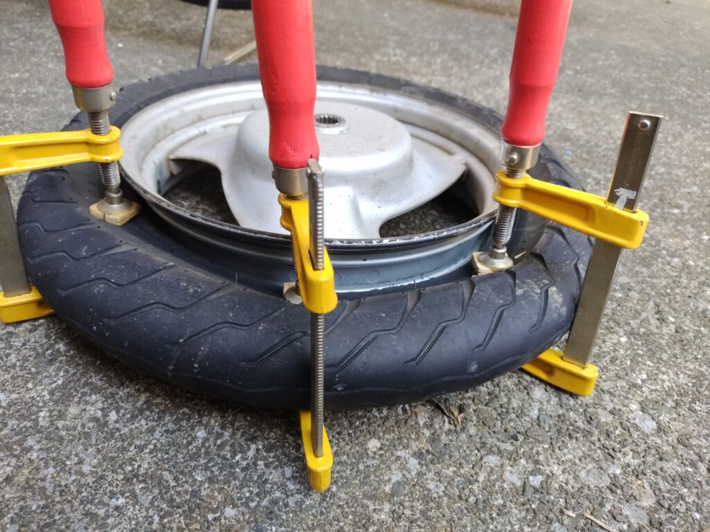 タイヤをクランプで挟んでビードを落とす